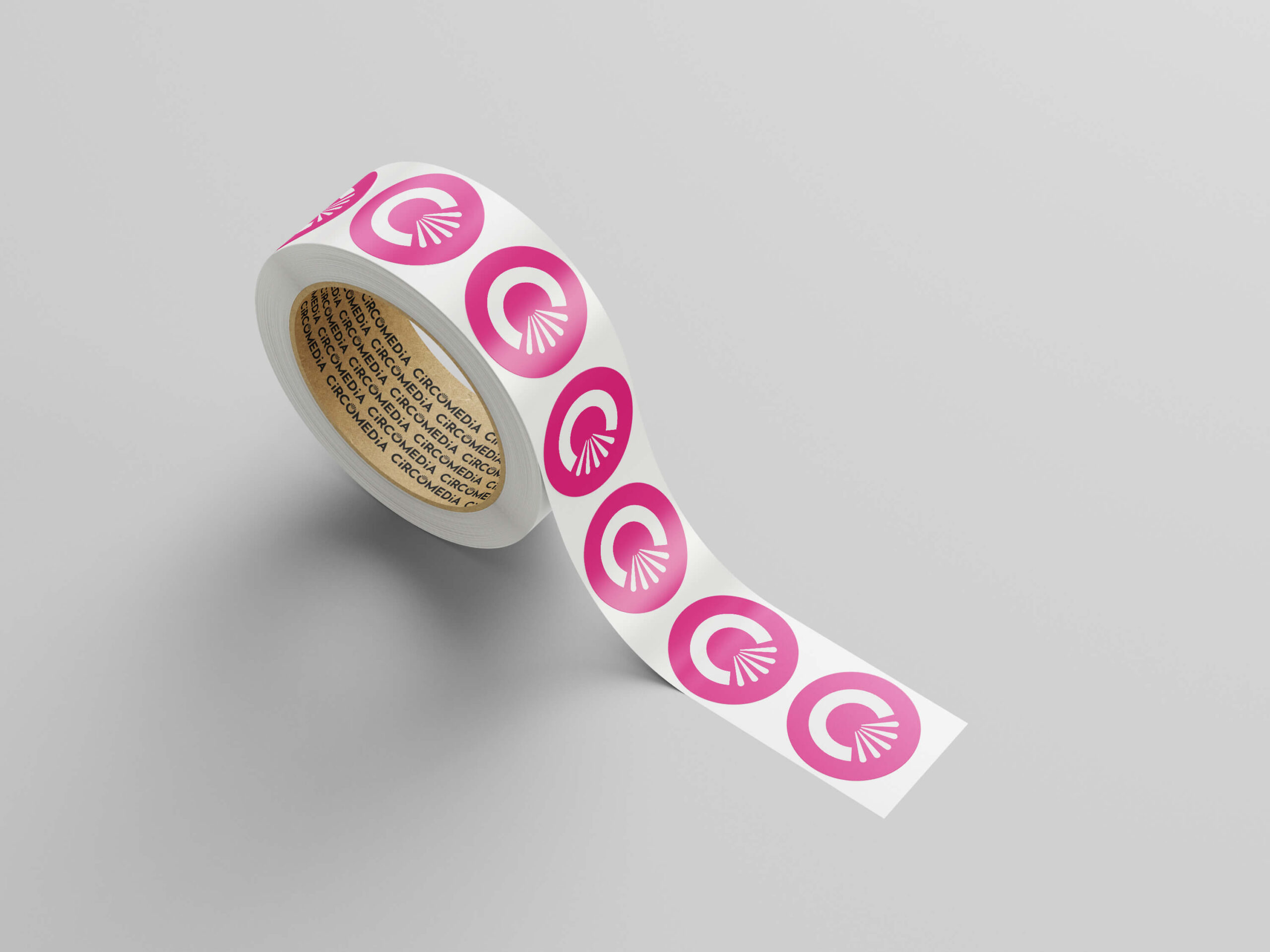 A roll of stickers with the circomedia logo on them mocked-up on a light background