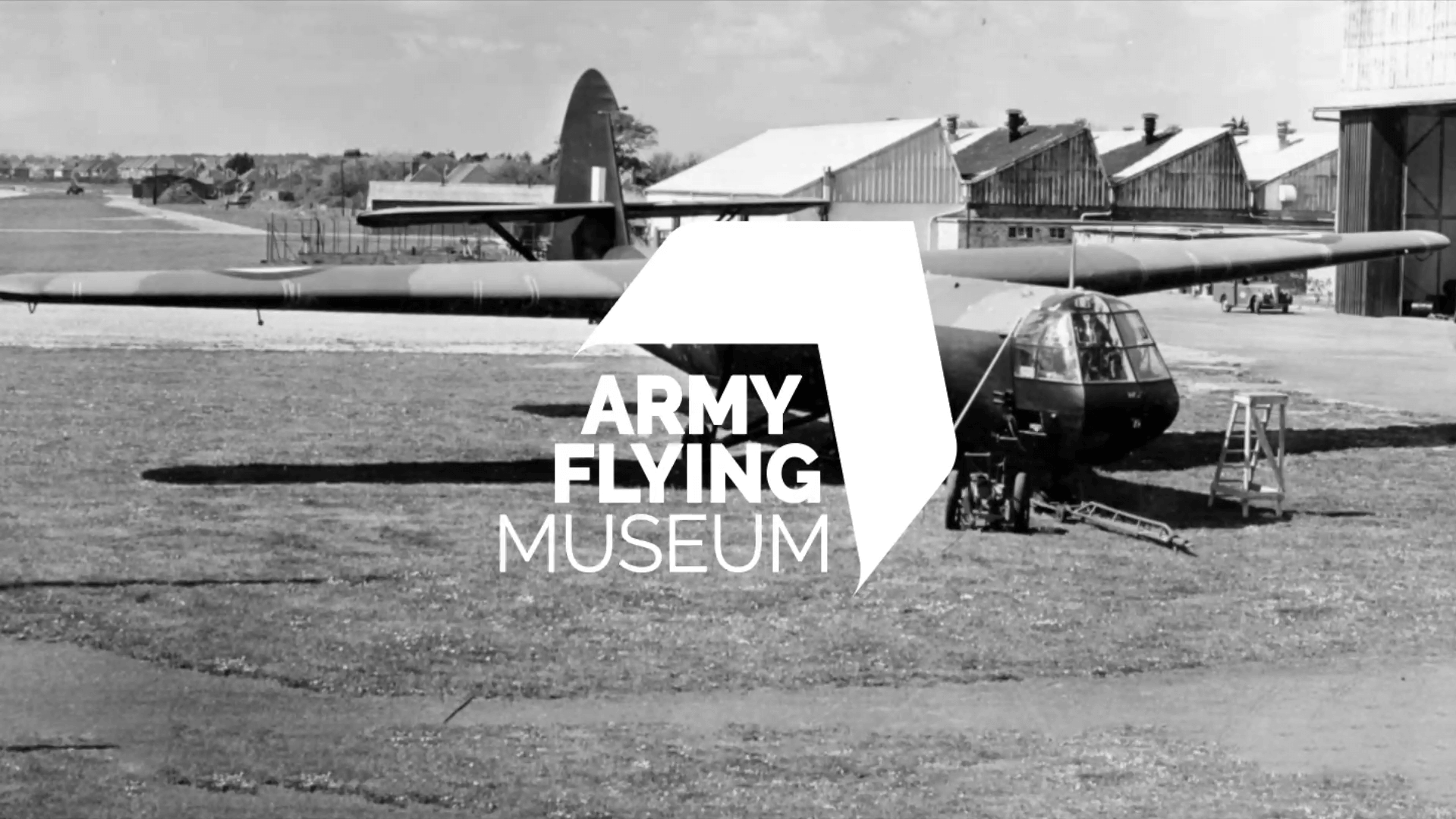 A screenshot of the Army Flying Museum logo on a black and white image of a plane.
