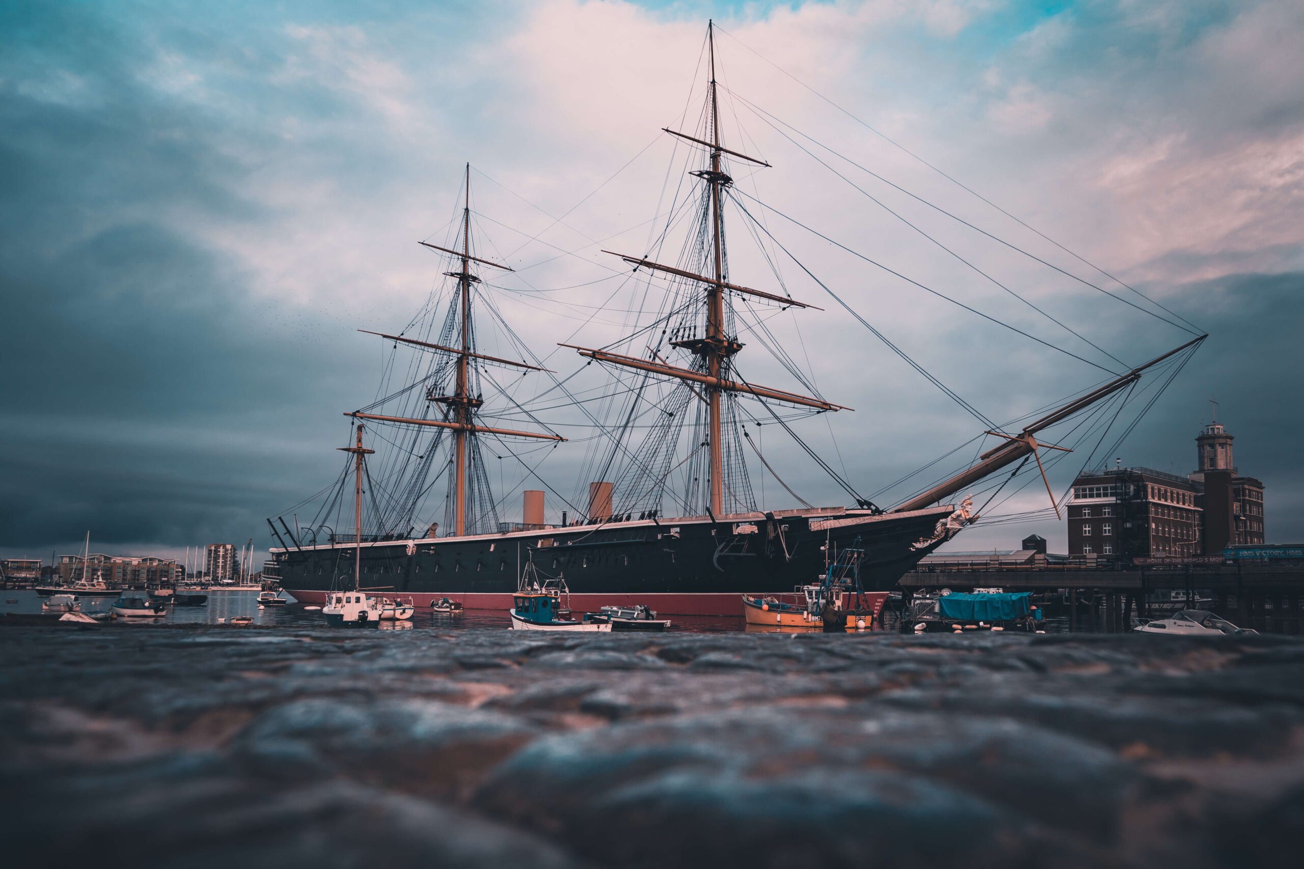 A shot of the HMS Warrior, part of the National Museum of the Royal Navy, from a low angle in the harbour. 