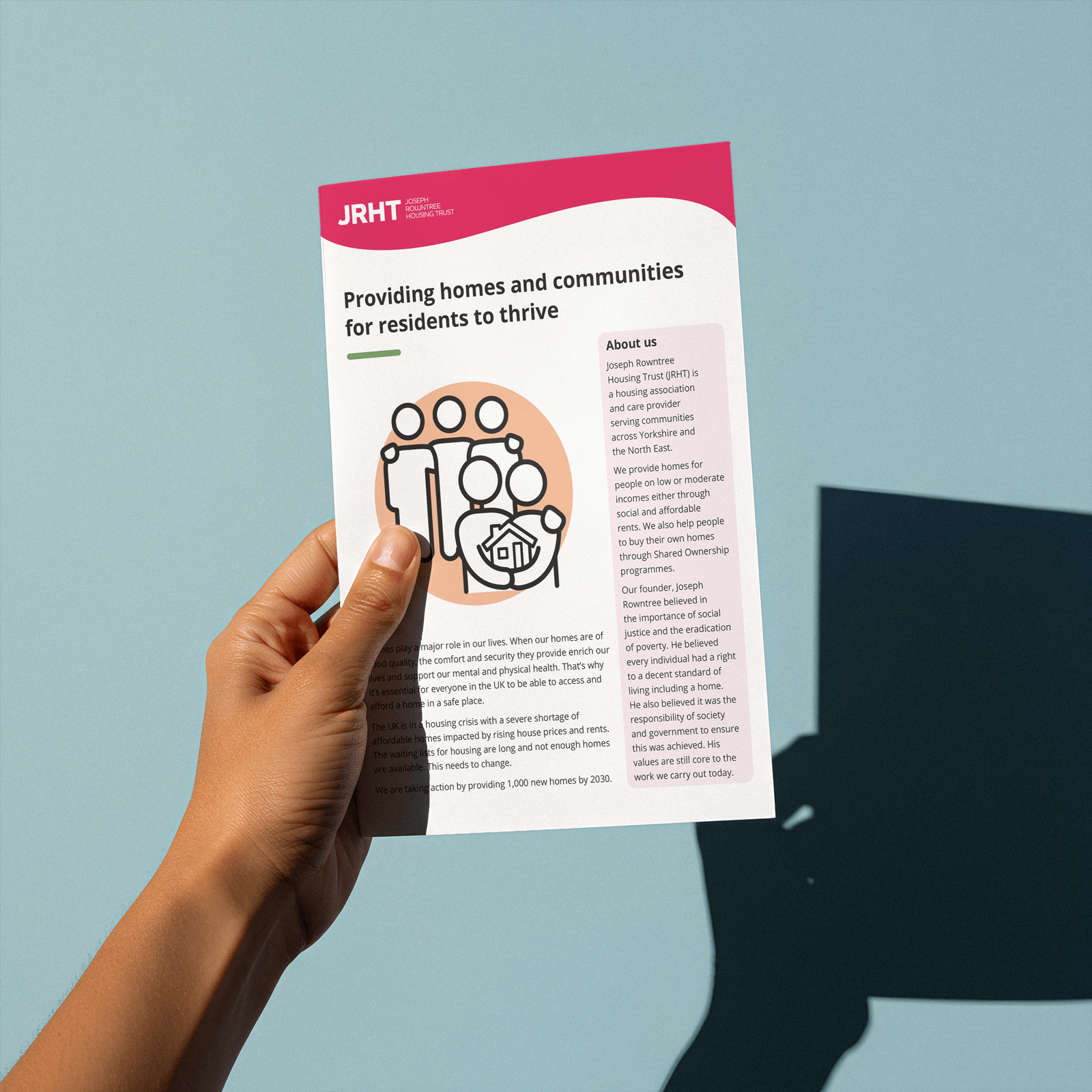 Circomedia prospectus being held in front of a rock with someone's hand holding it in place.