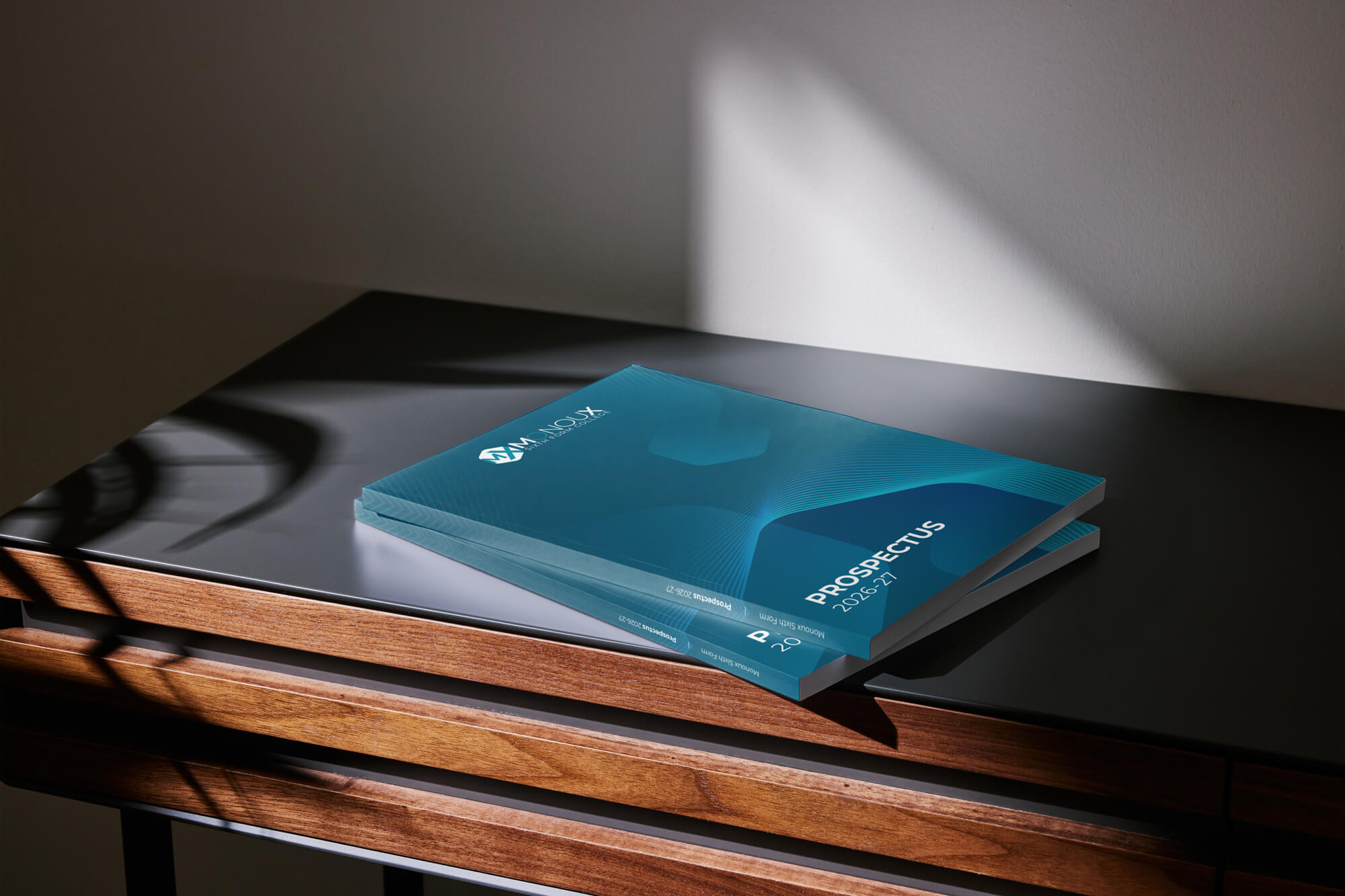 A mock-up showing two copies of the Sir George Monoux College 2026/27 prospectus on a table.