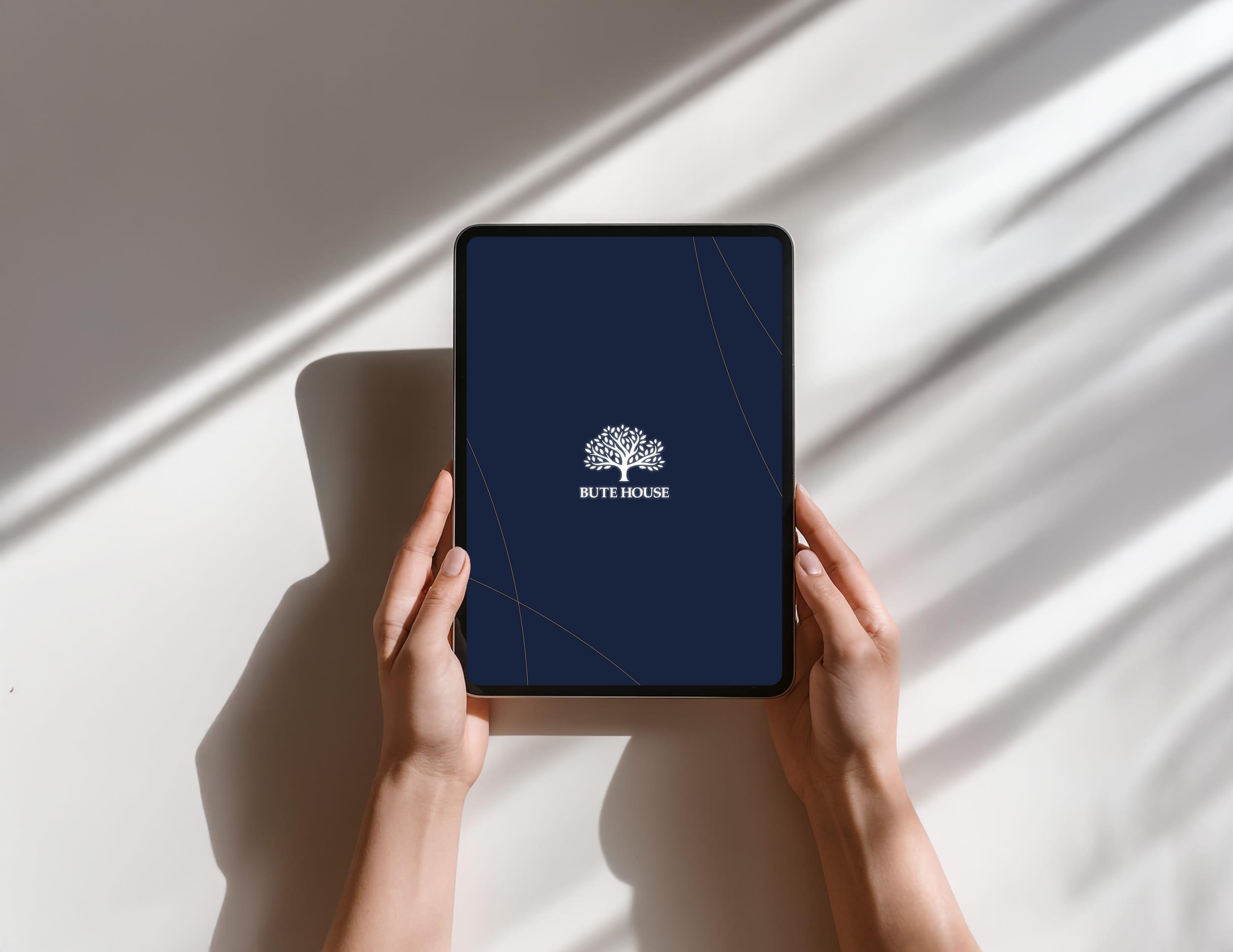 A mock-up of the Bute House logo and branding on a tablet screen.