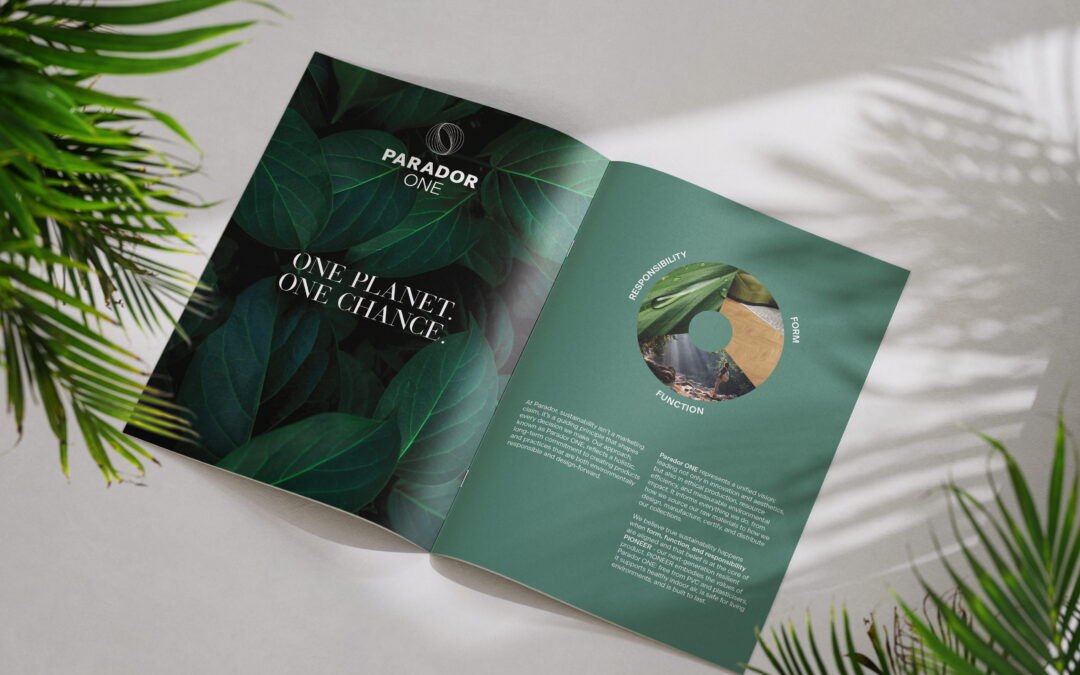 A mock-up showing the Parador sustainability brochure spread with sunlight shining on it whilst it sits between two plants.