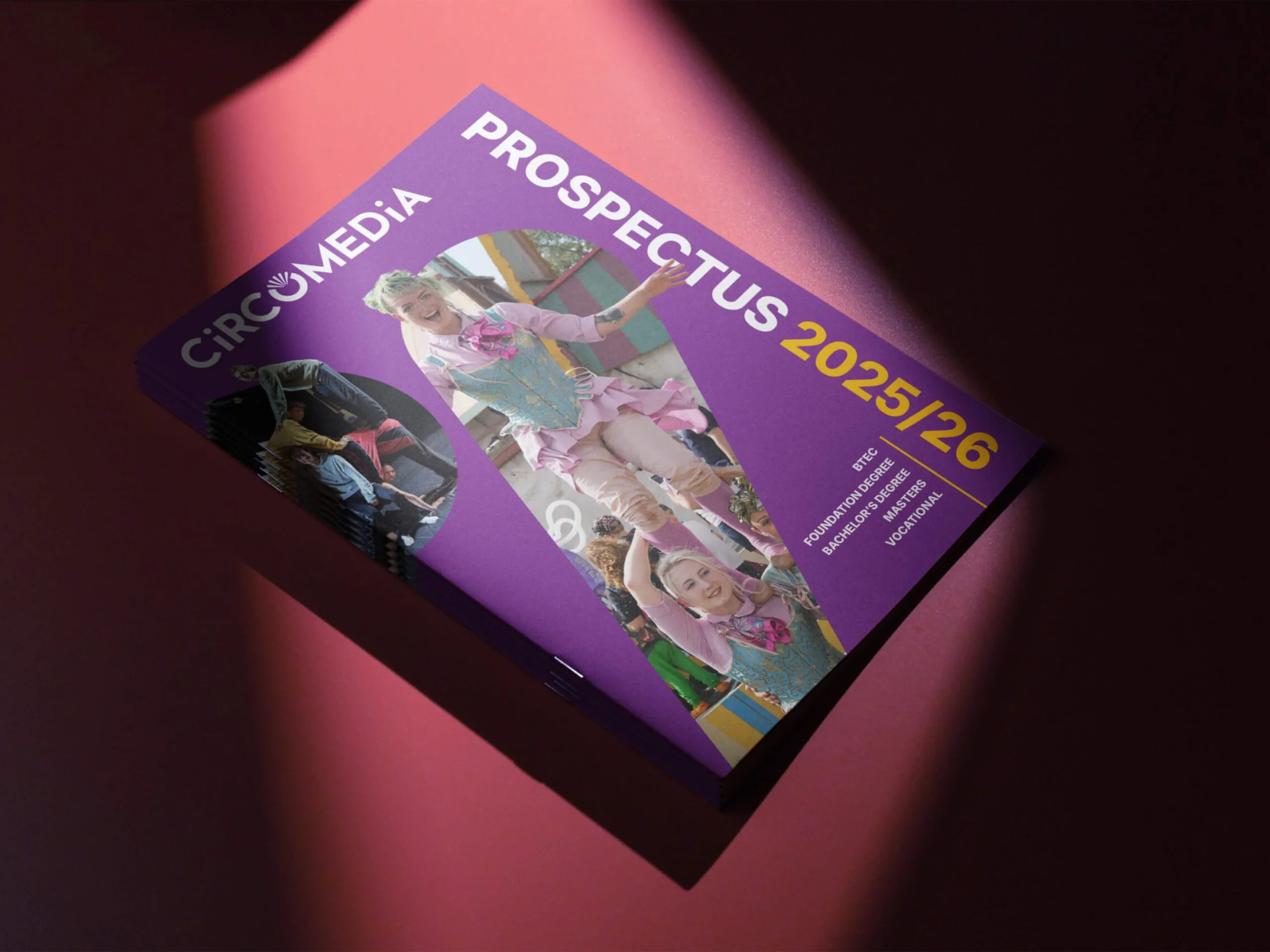 Circomedia's prospectus 2025/26 on a red background with a spotlight shining down on to it.